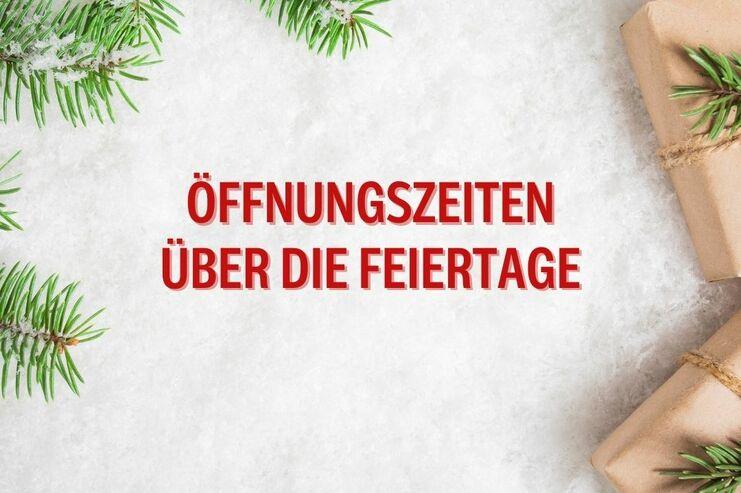 Text mit der Aufschrift „Öffnungszeiten über die Feiertage“ auf einem weißen, schneebedeckten Untergrund mit Tannenzweigen und Geschenken.