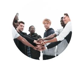 Eine Gruppe von sieben jungen Menschen steht im Kreis und legt ihre Hände übereinander. Hintergründe sind hell.