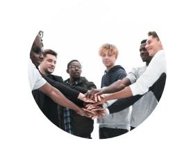 Eine Gruppe von sieben jungen Menschen steht im Kreis und legt ihre Hände übereinander. Hintergründe sind hell.