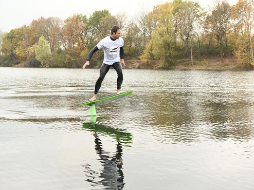 Mann macht Foil-Boarding auf dem Waldsee