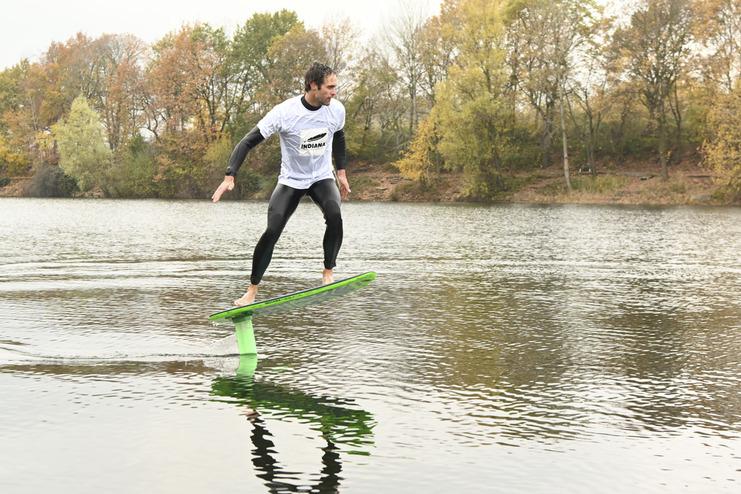 Mann macht Foil-Boarding auf dem Waldsee