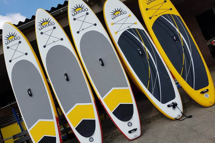 SUP Boards sind nebeneinander aufgereiht