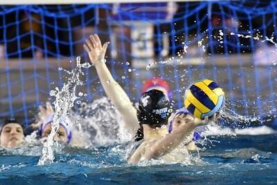 Wasserballspiel mit mehreren Spielerinnen, die um den Ball kämpfen und Spritzer im Wasser erzeugen.