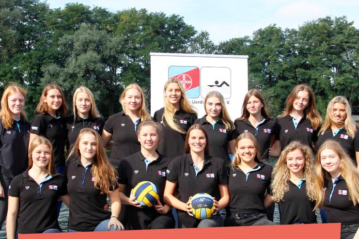 Gruppenfoto der U20 Damenmannschaft im Wasserball, alle tragen schwarze Poloshirts und halten Wasserbälle.