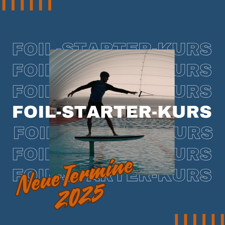 Junger Mann steht auf einem Foil-Board in einem Wasserbecken, mit einem Segel über ihm, unter einem gewölbten Dach.