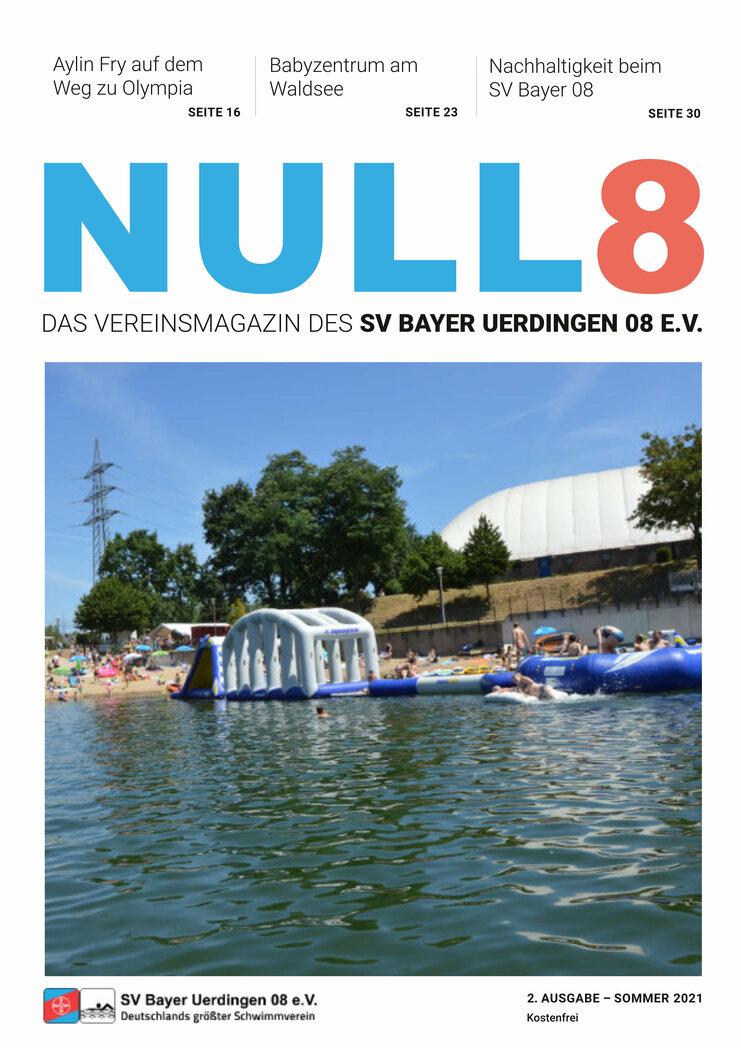 Familien verbringen Zeit am Waldrand mit Wasseraktivitäten; eine aufblasbare Wasserlandschaft ist im See sichtbar.