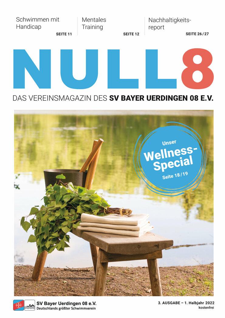 Holzstuhl mit einem Saunawassertopf, Birkenzweigen und Handtüchern am Ufer eines ruhigen Gewässers.